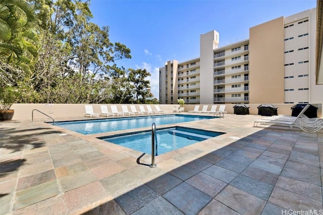 view of swimming pool featuring a community hot tub and a patio