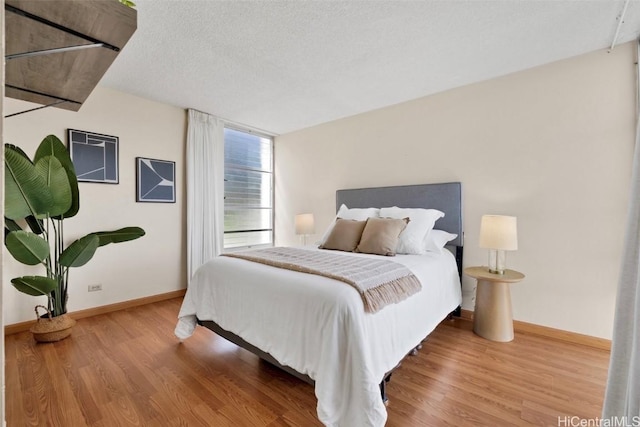 bedroom featuring hardwood / wood-style flooring and a textured ceiling