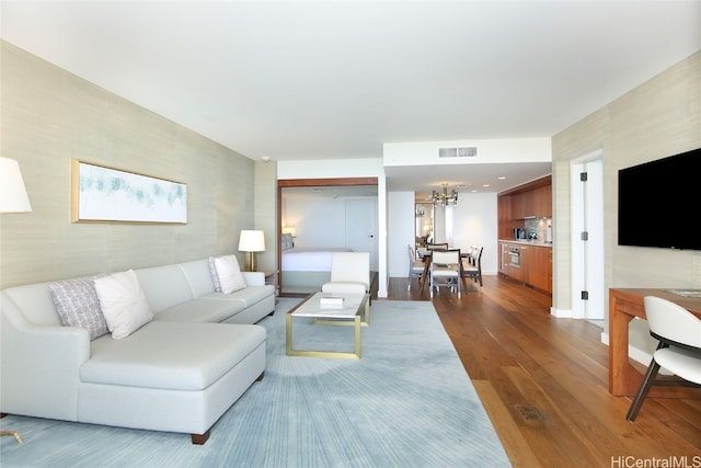 living room featuring a notable chandelier and hardwood / wood-style flooring