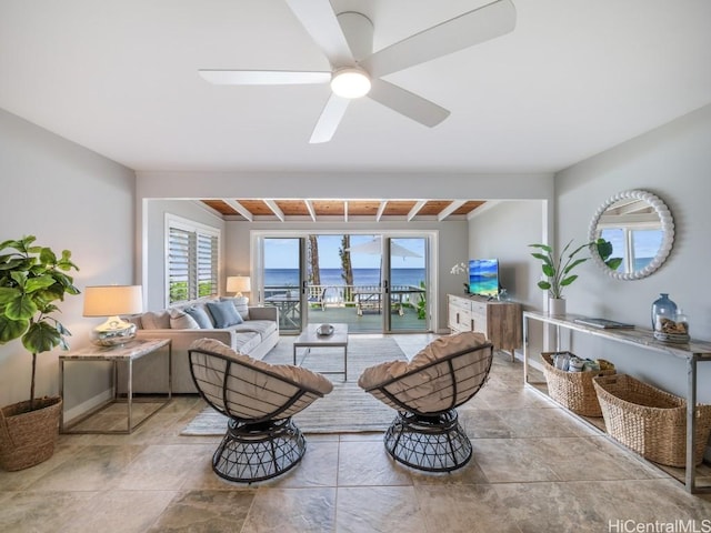 living room featuring beamed ceiling and ceiling fan