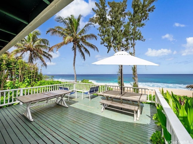 wooden terrace with a water view and a view of the beach