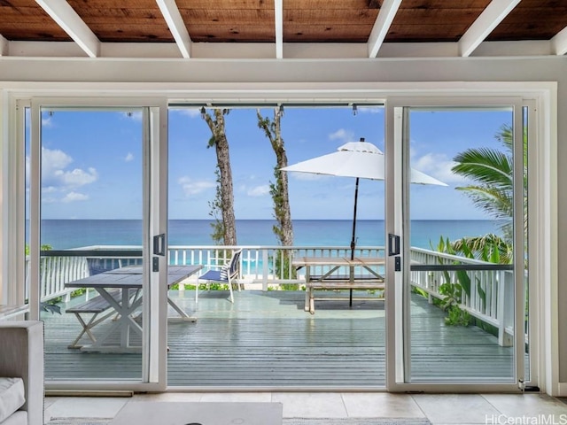 doorway to outside featuring a water view and light tile patterned floors