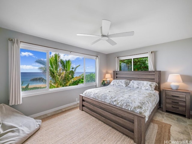 bedroom with a water view and ceiling fan