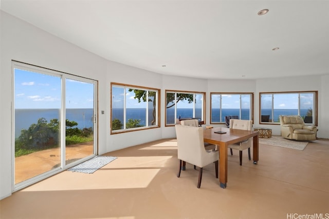 dining room featuring recessed lighting, concrete floors, and a water view