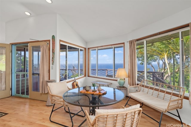 sunroom / solarium with a wealth of natural light, a water view, and vaulted ceiling