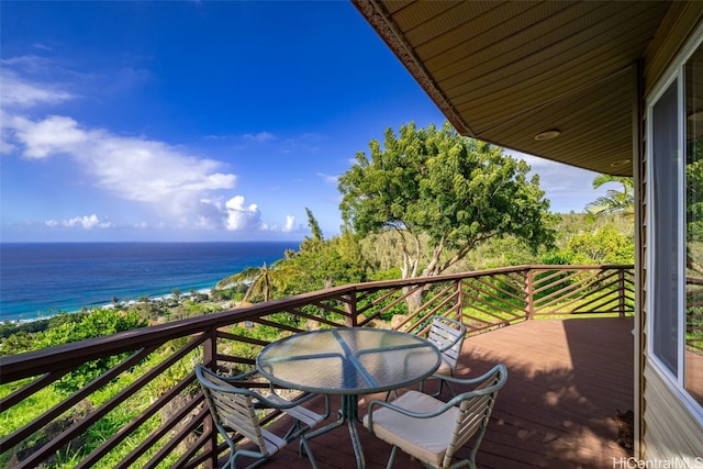 balcony with a view of the beach, outdoor dining area, and a deck with water view