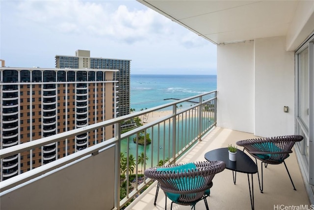 balcony featuring a beach view and a water view