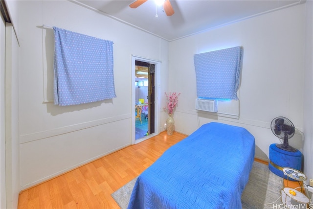 bedroom featuring cooling unit, wood-type flooring, and ceiling fan