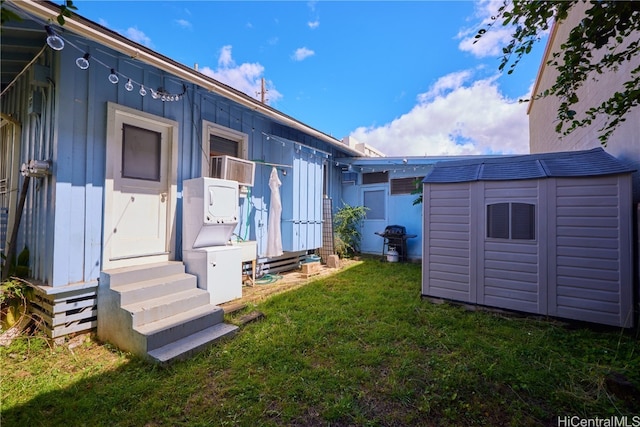 back of house featuring a storage shed and a lawn