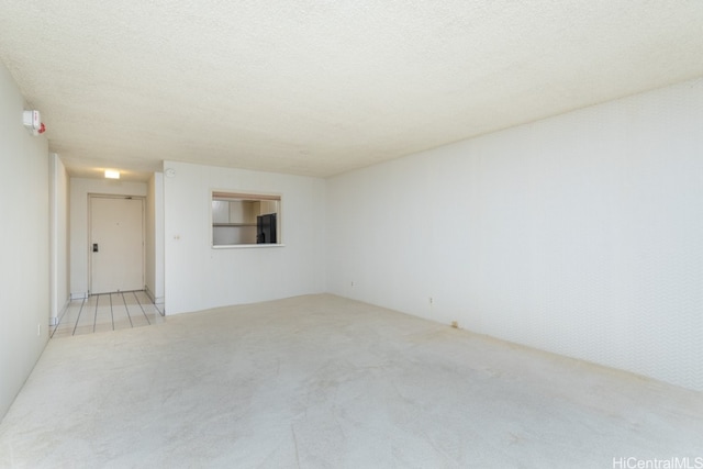 carpeted empty room featuring a textured ceiling