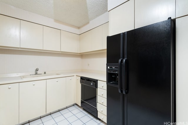 kitchen with sink, black appliances, light tile patterned flooring, white cabinetry, and a textured ceiling