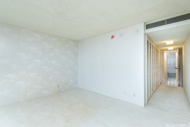 carpeted spare room with a textured ceiling