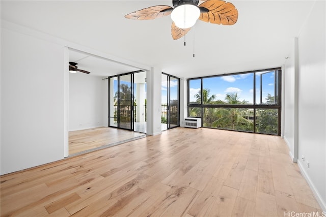 unfurnished room featuring light wood-type flooring, plenty of natural light, and floor to ceiling windows