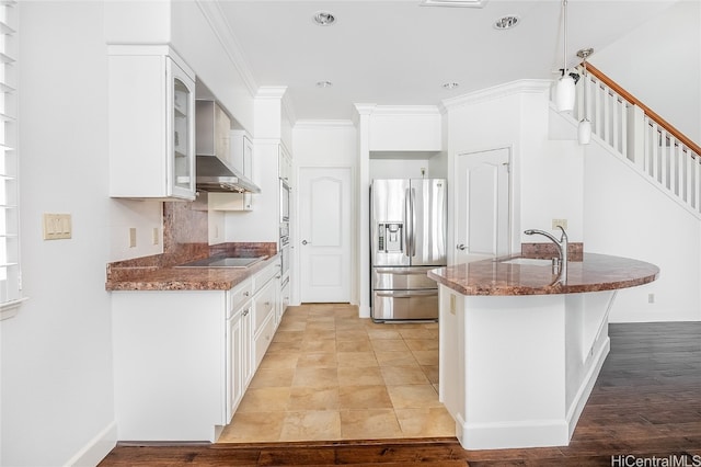 kitchen featuring white cabinetry, light hardwood / wood-style floors, wall chimney exhaust hood, ornamental molding, and stainless steel refrigerator with ice dispenser