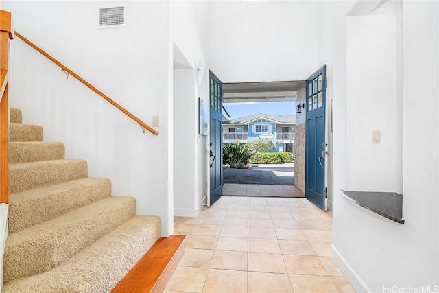 tiled foyer featuring a towering ceiling