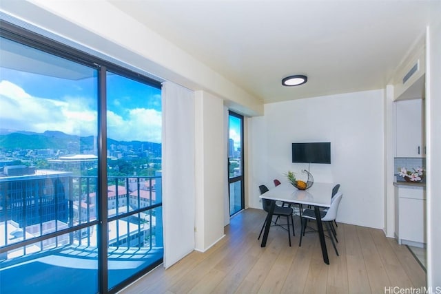 dining room with light hardwood / wood-style floors and a mountain view