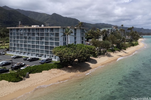 exterior space featuring a water and mountain view and a view of the beach