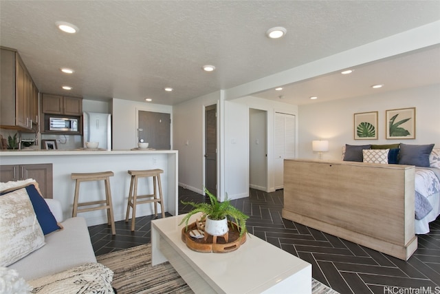 interior space with a textured ceiling and dark parquet flooring