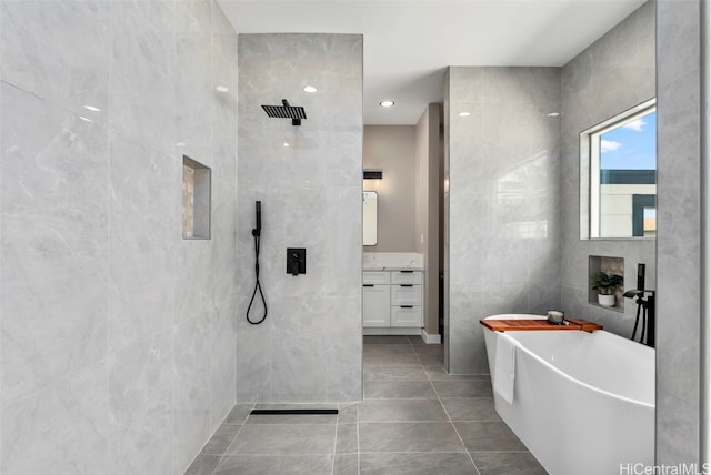 bathroom with tile walls, vanity, shower with separate bathtub, and tile patterned floors