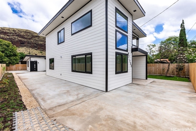 view of side of property with a storage unit and a patio area