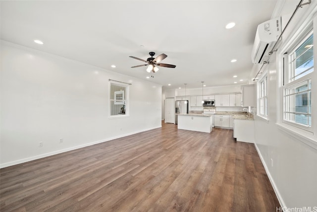 unfurnished living room featuring a wall unit AC, crown molding, dark hardwood / wood-style floors, and ceiling fan