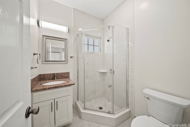 bathroom with vanity, toilet, tile patterned floors, and an enclosed shower