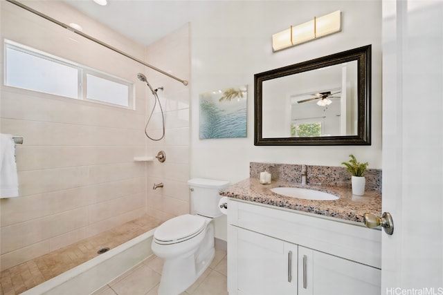 bathroom with vanity, toilet, tile patterned floors, and tiled shower