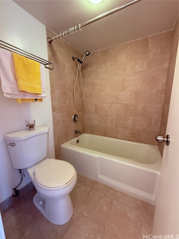 bathroom with tiled shower / bath, toilet, and tile patterned flooring