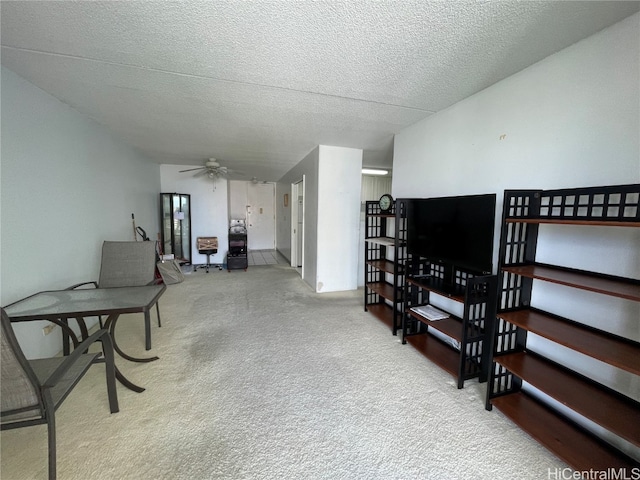 living room featuring ceiling fan, a textured ceiling, and light colored carpet