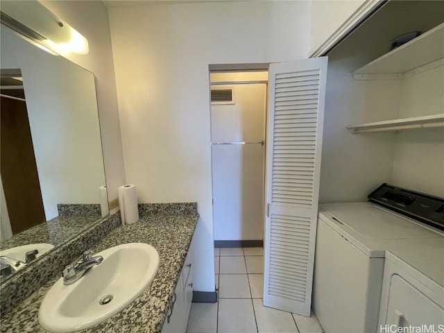 bathroom with sink, tile patterned floors, and separate washer and dryer