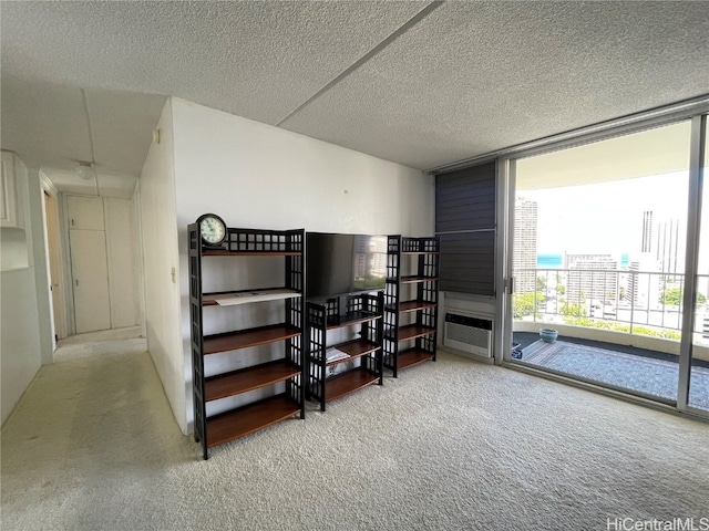 carpeted bedroom with expansive windows, a wall mounted AC, and a textured ceiling