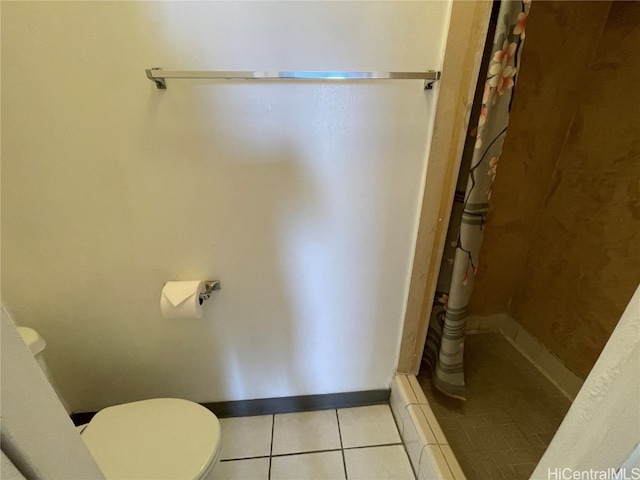 bathroom featuring tile patterned flooring, toilet, and a shower with curtain