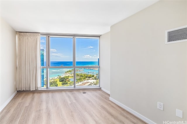 spare room featuring light hardwood / wood-style floors and a water view