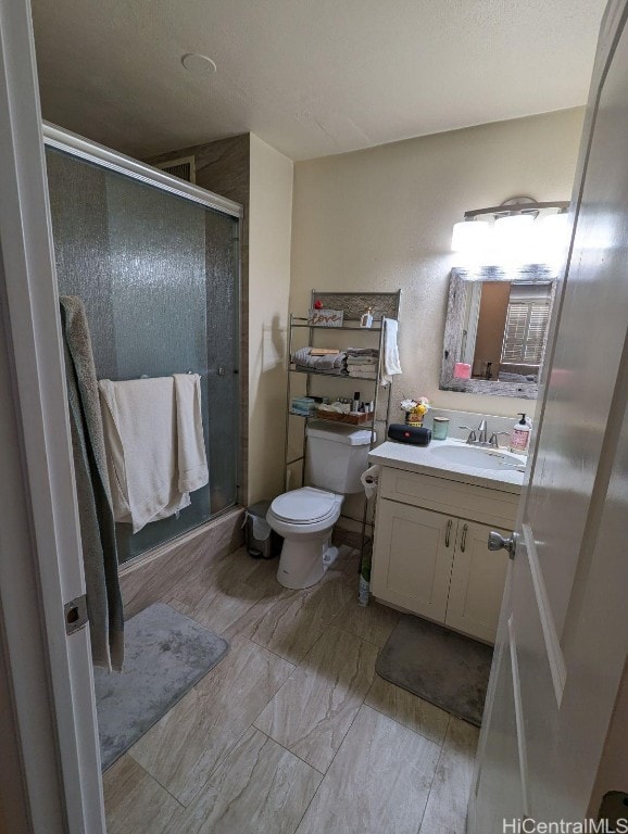 bathroom featuring vanity, toilet, and an enclosed shower