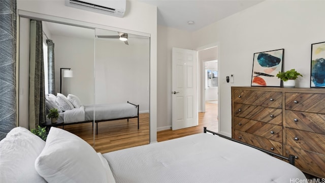 bedroom featuring a closet, hardwood / wood-style floors, and an AC wall unit