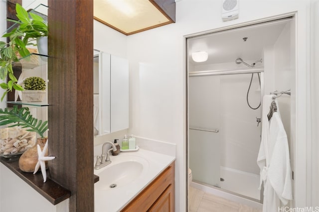 bathroom featuring a shower with door, vanity, toilet, and tile patterned floors