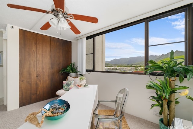 carpeted dining room featuring a wealth of natural light, a mountain view, and ceiling fan