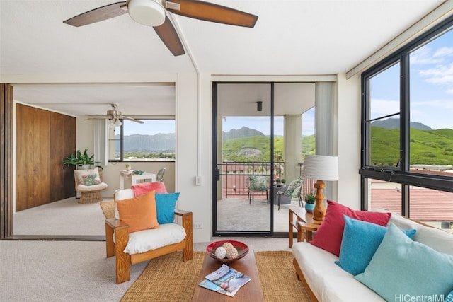 sunroom featuring a mountain view and ceiling fan