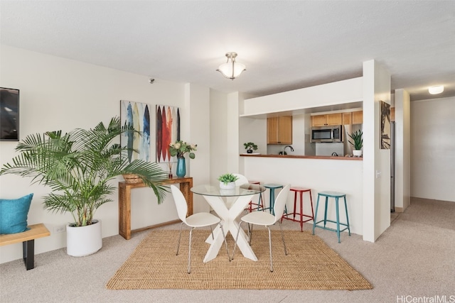 dining space featuring light colored carpet