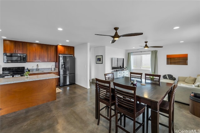 dining area with ceiling fan and sink