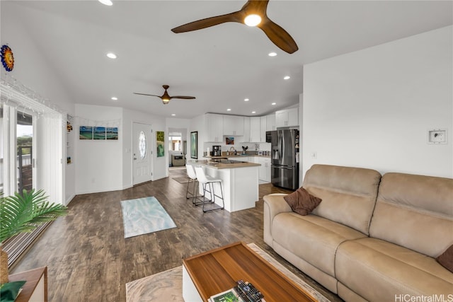 living room featuring lofted ceiling, dark hardwood / wood-style floors, and ceiling fan