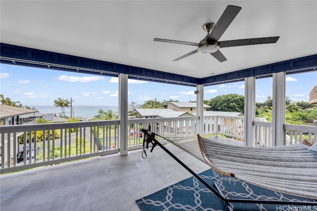 sunroom / solarium featuring a water view and ceiling fan