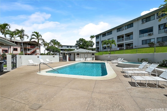 view of swimming pool with a community hot tub and a patio