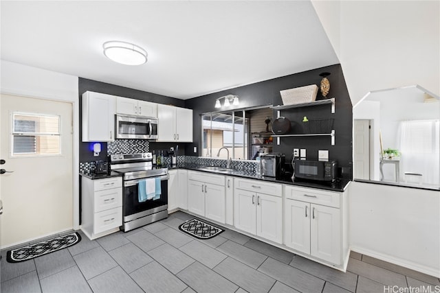 kitchen with sink, appliances with stainless steel finishes, white cabinets, and plenty of natural light