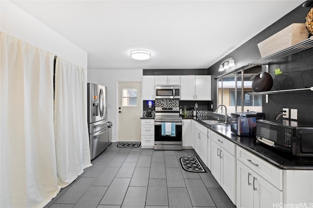 kitchen featuring sink, white cabinets, decorative backsplash, and stainless steel appliances