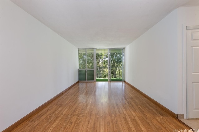 unfurnished room featuring light hardwood / wood-style floors and floor to ceiling windows