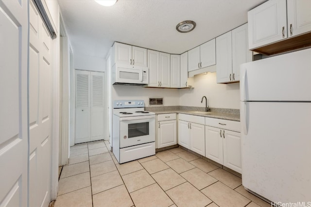 kitchen with white cabinets, light tile patterned floors, a textured ceiling, sink, and white appliances