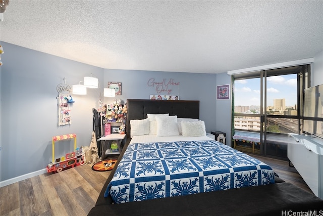 bedroom featuring dark hardwood / wood-style floors, a textured ceiling, and floor to ceiling windows