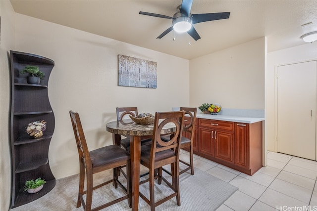 dining area with ceiling fan and light tile patterned flooring