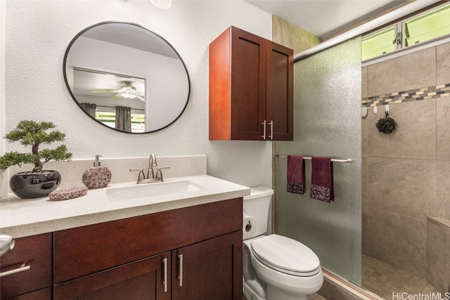 bathroom with toilet, an enclosed shower, vanity, and ceiling fan